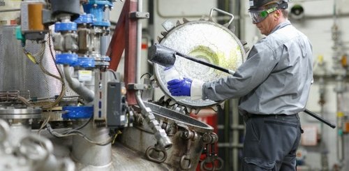 MOWITAL® Mitarbeiter beim Arbeiten vor einer Maschine in der Anlage zur PVB-Produktion.