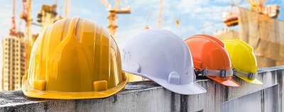 Safety helmets in different colors on a wall.